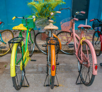 A,Row,Of,Vintage,Bicycles,Painted,Bright,Colors,,Parked,On